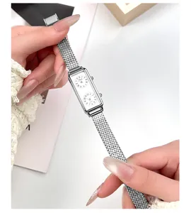 Gros plan d'une montre à double cadran argentée avec bracelet en maille d'acier