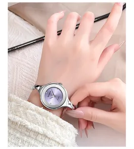 Detail of silver bangle watch with light purple sunray dial worn on female wrist