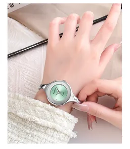 Detail of elegant silver bracelet watch with a mint green sunray dial on a wrist