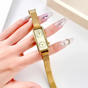 Vintage gold square dual-dial watch with mesh band worn by model on white background