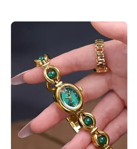 Macro detail of GEDI gold watch with emerald oval dial and matching jewelry ring