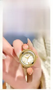 Détail de la montre GEDI avec cadran en nacre, gemmes roses et bracelet en cuir brun