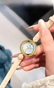 Détail montre femme GEDI avec cadran en nacre et bracelet en cuir beige au poignet