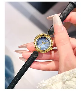 Gros plan d'une montre quartz bohème pour femme avec cadran bleu et lunette dorée