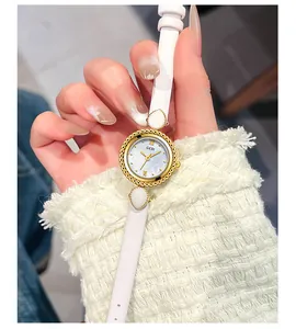 Gros plan montre femme GEDI avec bracelet cuir blanc et cadran doré en nacre élégant