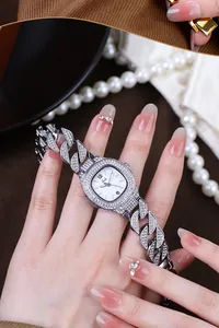 Close-up of a silver luxury square watch featuring diamond-encrusted Cuban link bracelet