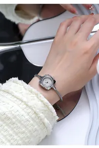 Detail of square silver ladies watch with braided rope metal bracelet on wrist
