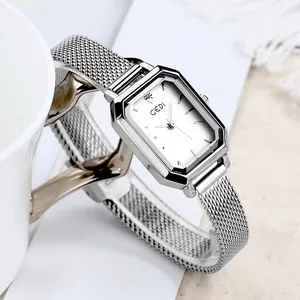 Elegante silberne Damen-Quarzuhr mit achteckigem Gehäuse und Netzarmband an einer Tasse