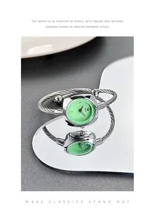 Detail of elegant square mint green quartz watch with silver cable wire bracelet band