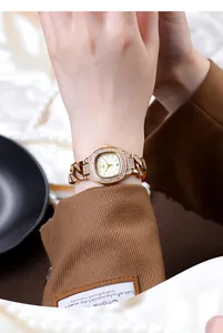 Close-up of luxury gold quartz watch for women with sparkling crystal stones on wrist