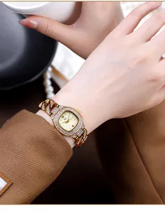 Close-up of elegant gold quartz watch with sparkling rhinestones on woman's wrist