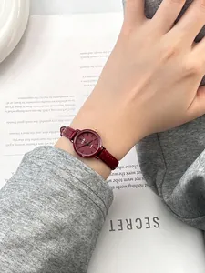 Detailed view of elegant small red leather strap quartz watch on a model wrist