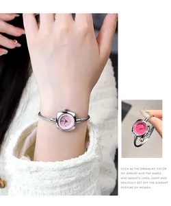 Detail of silver twisted cable bracelet watch with a pink dial on a woman's wrist