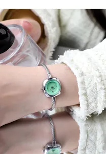 Close-up of GEDI quartz watch with silver twisted cable band and light green swan dial