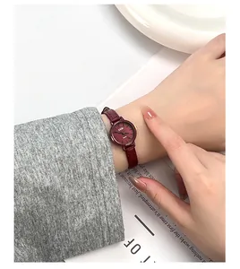 Close-up of GEDI vintage burgundy leather strap watch with matching dial on female wrist