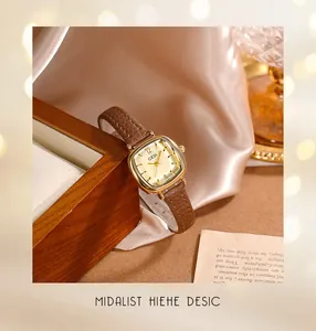 Vue détaillée d'une montre dorée vintage avec bracelet en cuir brun et décor de soie