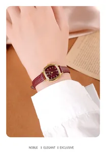 Détail de la montre carrée dorée vintage avec bracelet et cadran en cuir rouge foncé