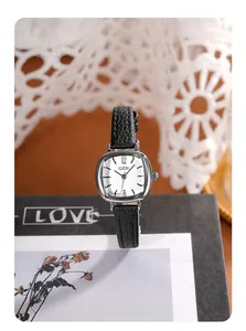 Montre carrée élégante en argent avec bracelet en cuir noir sur une boîte décorative