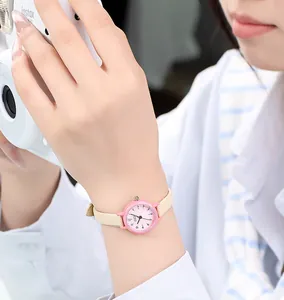 Montre à quartz chic rose pour femme avec bracelet en cuir crème portée au poignet