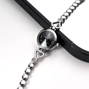 Detailed view of silver heart bracelet watch with black dial and crystal accents