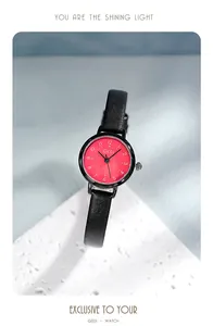 Détail de la montre GEDI à quartz avec cadran rouge et bracelet fin en cuir noir sur pierre