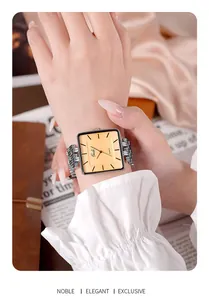 Gros plan d'une montre carrée argentée pour femme avec cadran champagne et bracelet gourmette