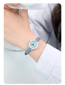 Gros plan d'une montre à quartz bleu clair portée au poignet avec bracelet en cuir chic