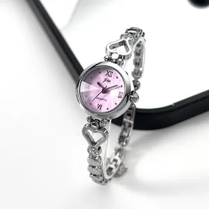 Detailed close-up of a silver heart-shaped bracelet watch with a pink Roman dial
