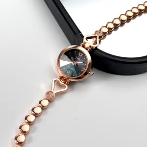 Detail of rose gold watch dial with Roman numerals and heart-shaped crystal bracelet