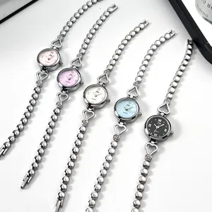 Macro detail of various quartz watches with heart link bracelets and colorful dials
