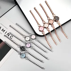 Multiple colors of heart-shaped link watches with roman numeral dials displayed on a tray