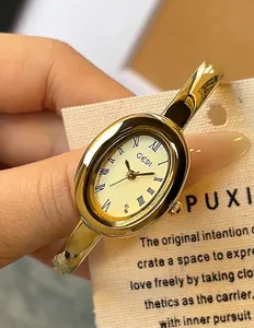 Detalle del reloj GEDI vintage de pulsera dorada ovalada con números romanos negros