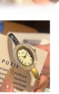 Nahaufnahme der Luxus-Quarzuhr mit ovalem Gehäuse, Diamantlünette und Goldarmband
