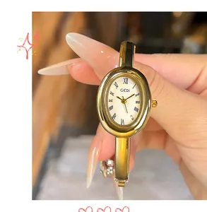 Detalle de reloj de cuarzo ovalado dorado con esfera blanca y números romanos dama