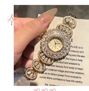 Detailopname van luxe goudkleurig dameshorloge met strass-steentjes op wijzerplaat en band