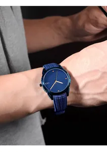Detail of blue quartz watch with textured silicone strap and gold hands on large dial