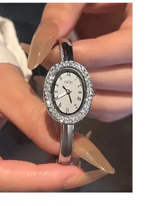 Detailaufnahme einer silbernen ovalen Armreif-Uhr mit Kristalllünette und römischen Ziffern