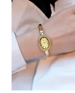 Detailansicht der GEDI ovalen Gold-Uhr mit Diamantlünette und römischen Ziffern am Handgelenk