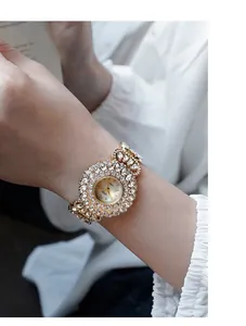 Close-up van GEDI gouden luxe horloge met fonkelende kristallen en champagne wijzerplaat