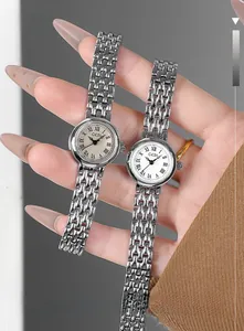 Detail of elegant silver mesh strap women's watch with Roman numeral dial on wrist
