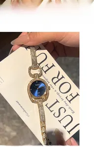 Detail of luxury gold watch with blue sunray dial and crystal encrusted horseshoe case