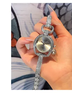 Detailed close-up of a silver luxury women's watch with full diamond-encrusted band