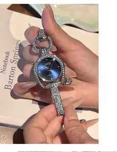 Macro detail of GEDI women's silver watch featuring a blue sunray dial and rhinestone-set band