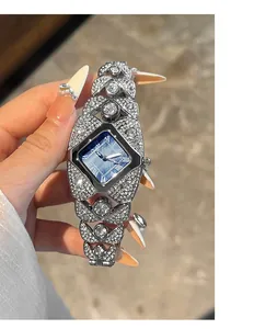 Gros plan d'une montre de luxe pour femme avec cadran bleu et bracelet feuillage