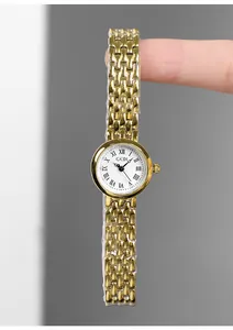 Detail view of dainty gold stainless steel watch with roman numerals on white dial