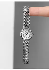 Close-up of a silver stainless steel women's watch with Roman numerals on white dial