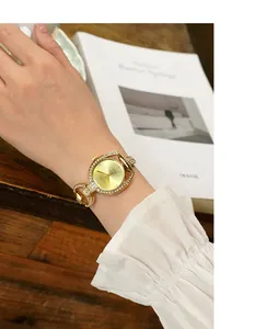 Detail of luxury gold rhinestone women's watch with starry dial on a model wrist