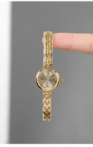 Dettaglio di un piccolo orologio vintage dorato con quadrante grigio effetto sole