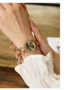 Close-up of golden GEDI women watch with rhinestone bezel and elegant dark grey dial