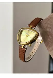 Detail of GEDI women's watch with golden triangle case and brown leather strap on wrist